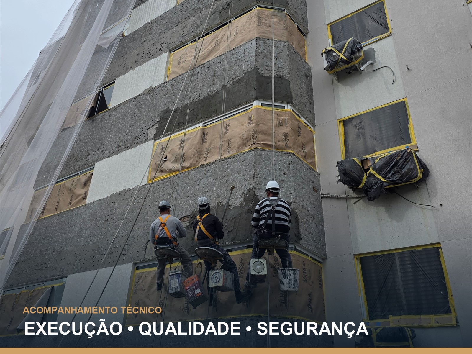 Equipe em trabalho em altura durante fiscalização de obra em fachada